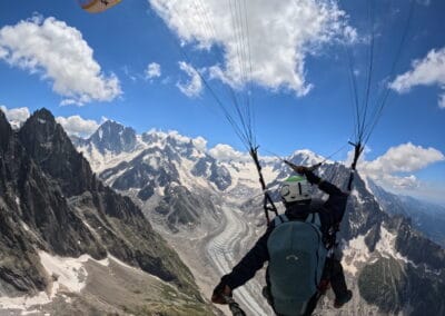 Photo de deux passagers en biplace parapente survolant la Mer de Glace