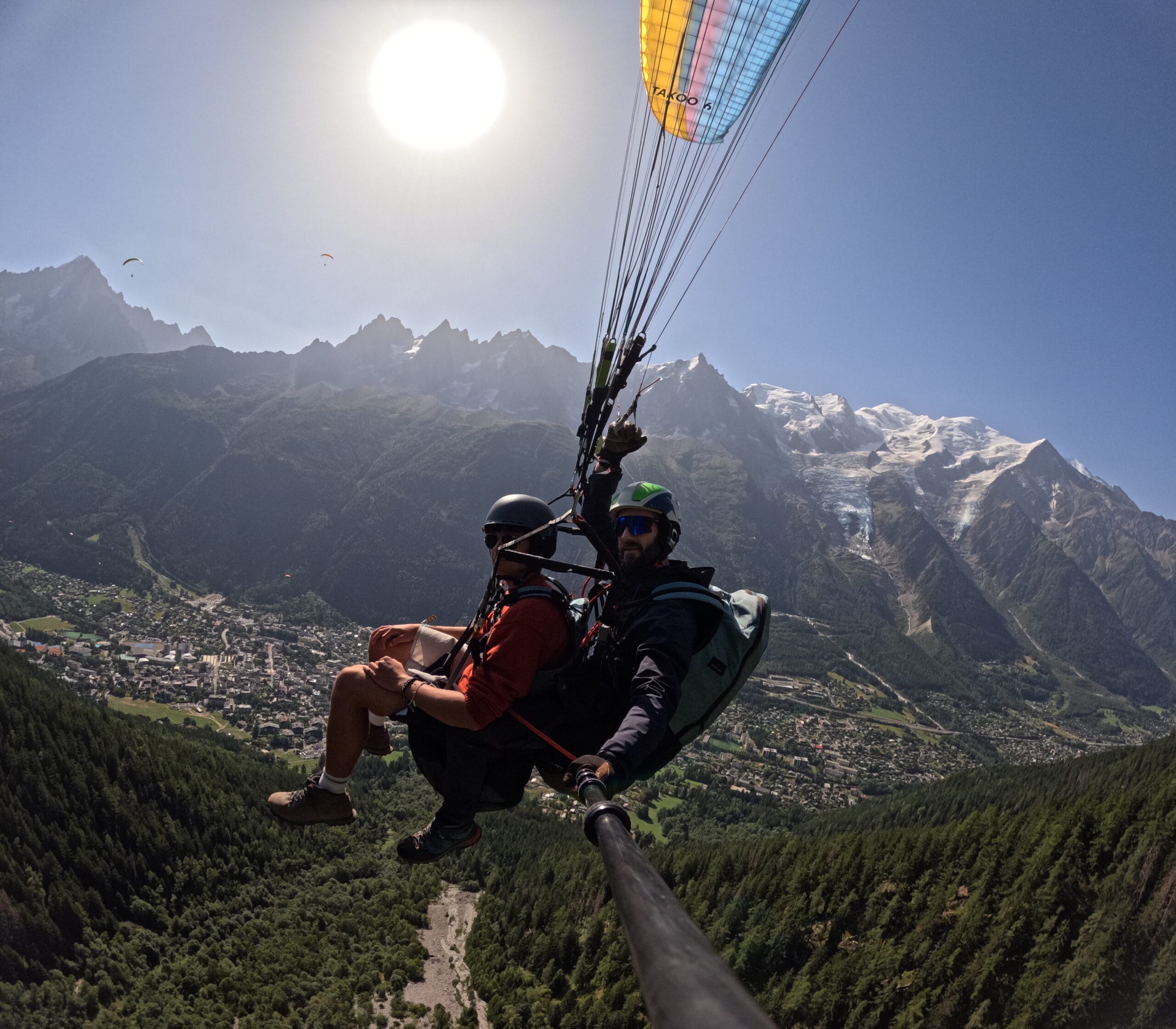Morning Paragliding Photo of a passenger and their pilot under a paraglider under a perfect blue sky