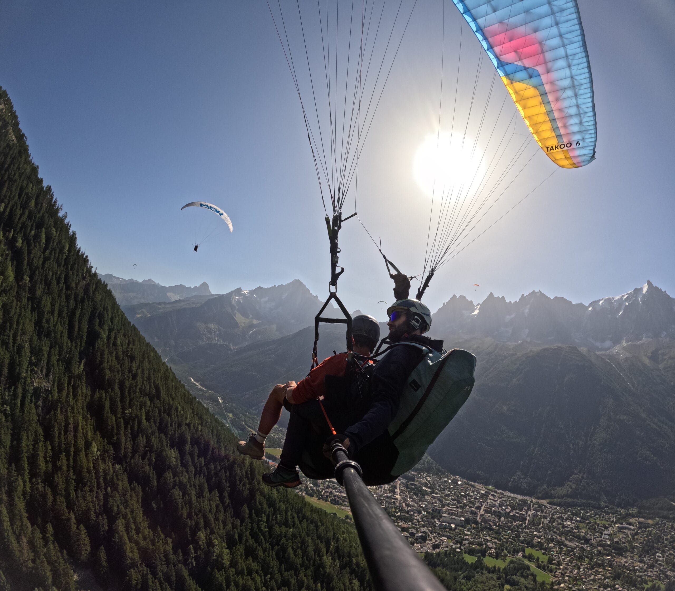 Morning Paragliding Photo of a passenger and their pilot under a paraglider under a perfect blue sky