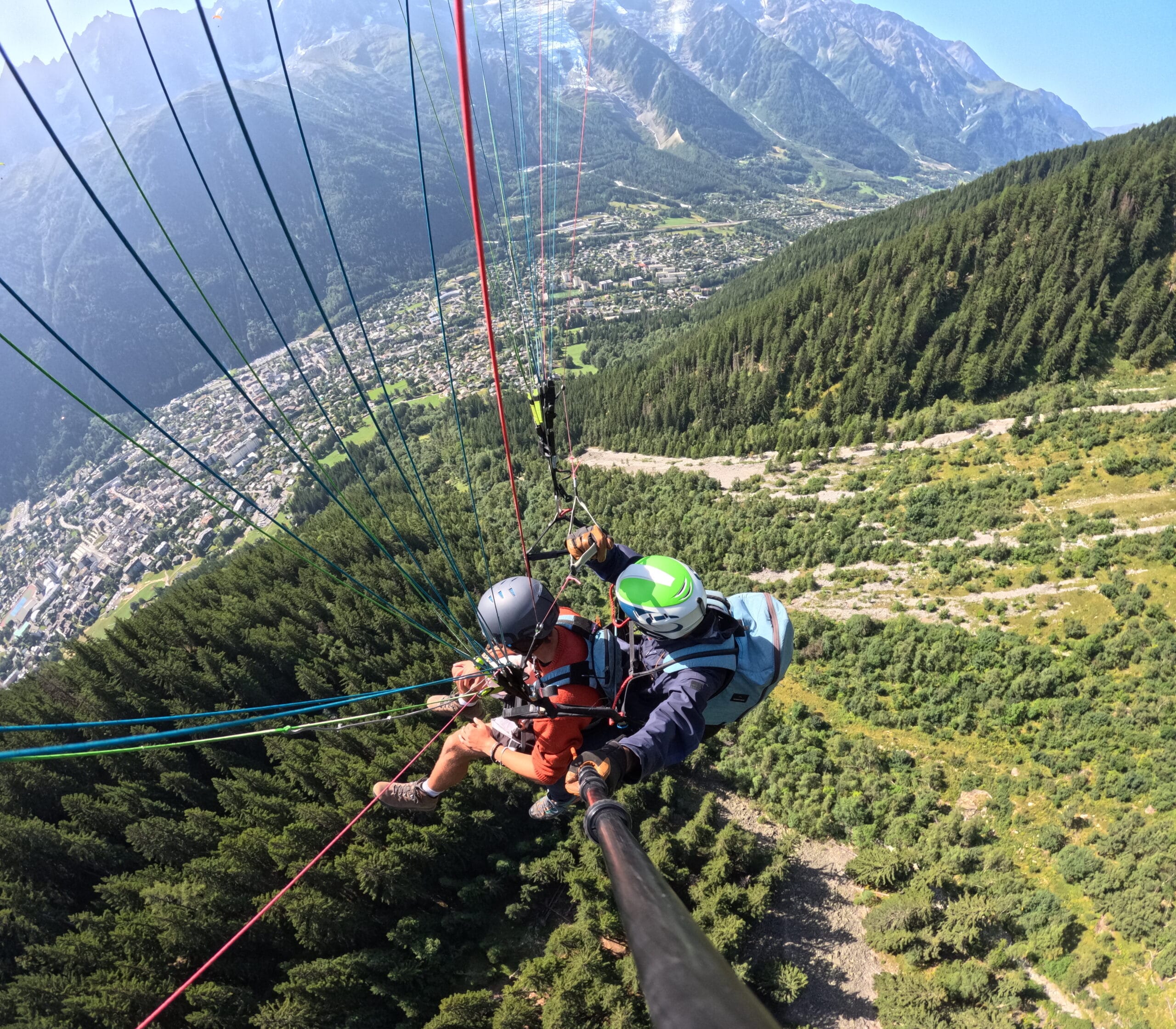 Morning Paragliding Photo of a passenger and their pilot under a paraglider under a perfect blue sky
